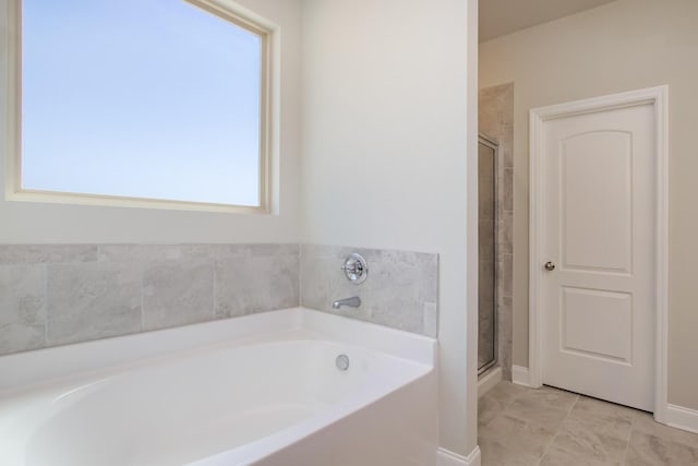 bathroom featuring a bath, a wealth of natural light, and a stall shower