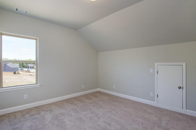 bonus room with visible vents, baseboards, light colored carpet, and vaulted ceiling