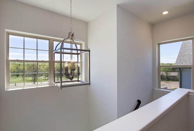 corridor with an inviting chandelier and recessed lighting