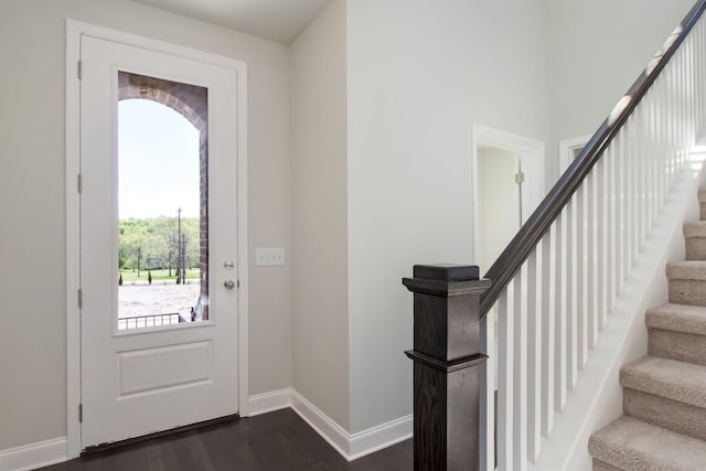 entryway with stairs, dark wood-style flooring, and baseboards