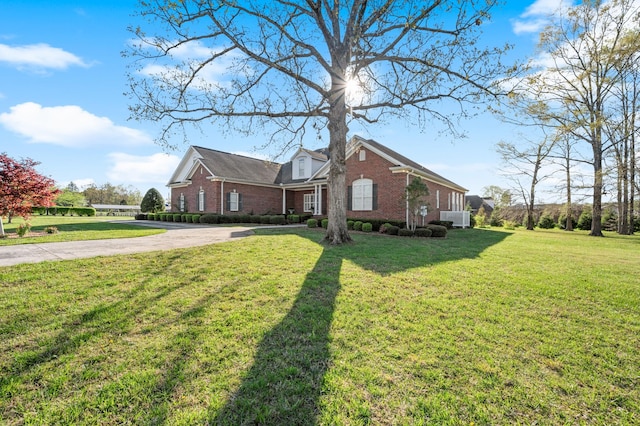 view of property exterior featuring brick siding, a lawn, and concrete driveway