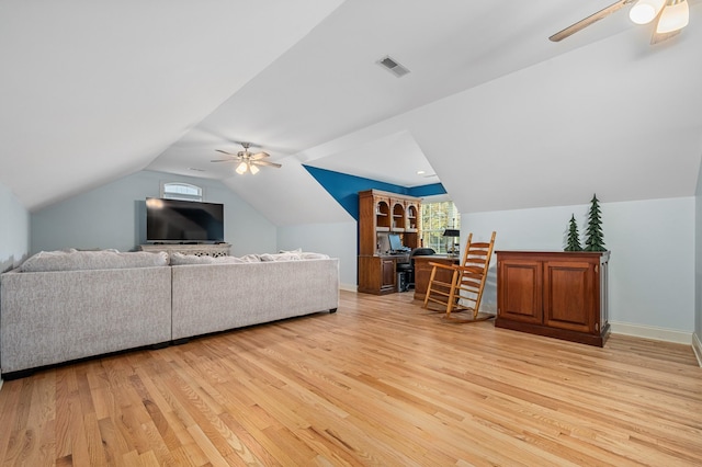 living area with visible vents, light wood-style flooring, a ceiling fan, and vaulted ceiling