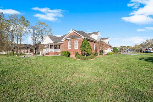 view of front of property featuring brick siding, a front yard, and a porch