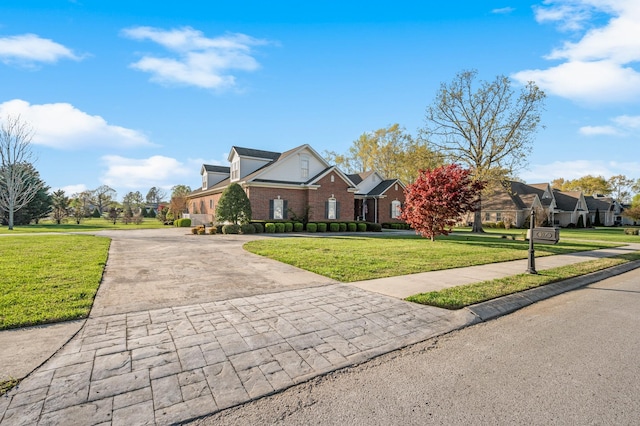 traditional-style house with brick siding, a front lawn, and driveway