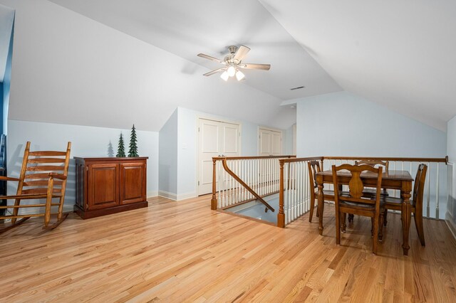 additional living space with baseboards, a ceiling fan, light wood-style floors, and lofted ceiling
