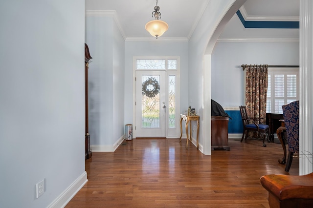 entrance foyer featuring crown molding, arched walkways, wood finished floors, and baseboards
