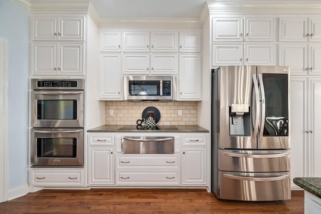kitchen featuring white cabinetry, tasteful backsplash, a warming drawer, and appliances with stainless steel finishes