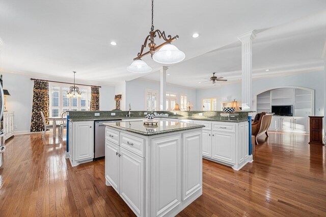 kitchen with a center island, a sink, ornamental molding, ceiling fan with notable chandelier, and stainless steel dishwasher
