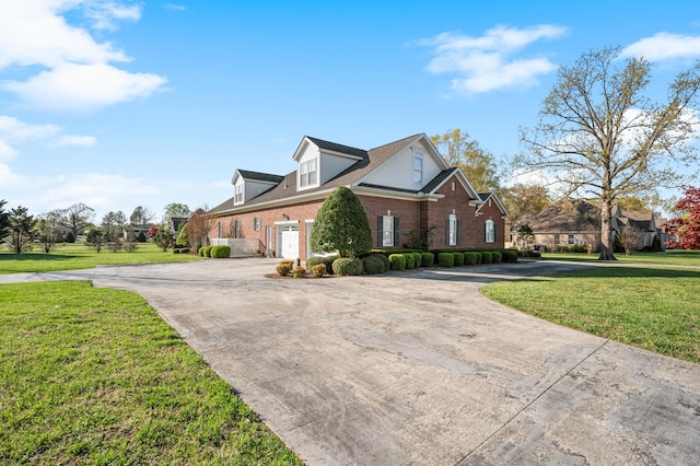view of front of property featuring a front yard, curved driveway, and brick siding