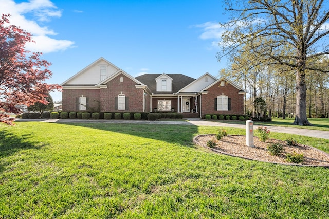 traditional home featuring a front yard and brick siding