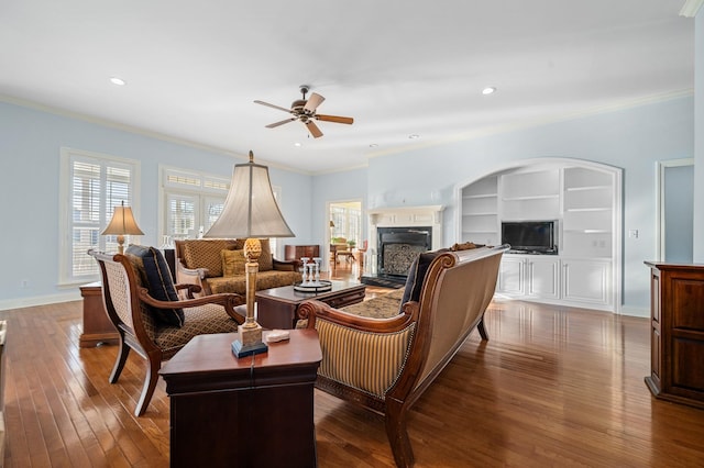 living room featuring ornamental molding, a ceiling fan, and a fireplace