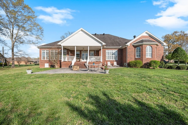 rear view of house featuring brick siding, a patio, and a lawn