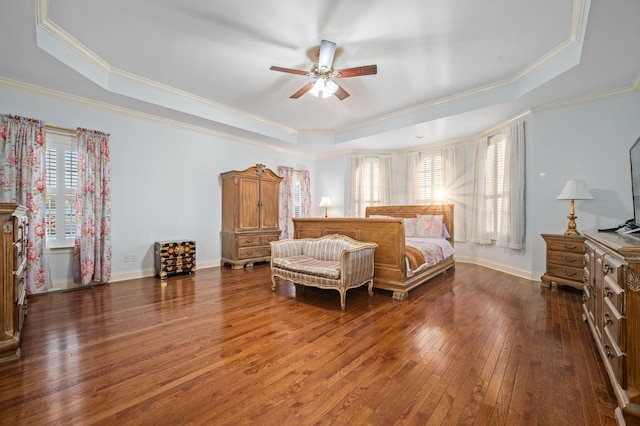 bedroom with baseboards, ornamental molding, a ceiling fan, a raised ceiling, and hardwood / wood-style flooring