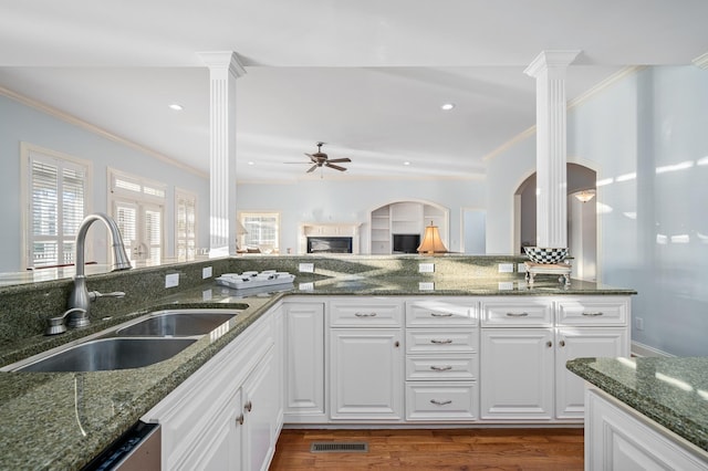 kitchen featuring a sink, ornamental molding, and decorative columns