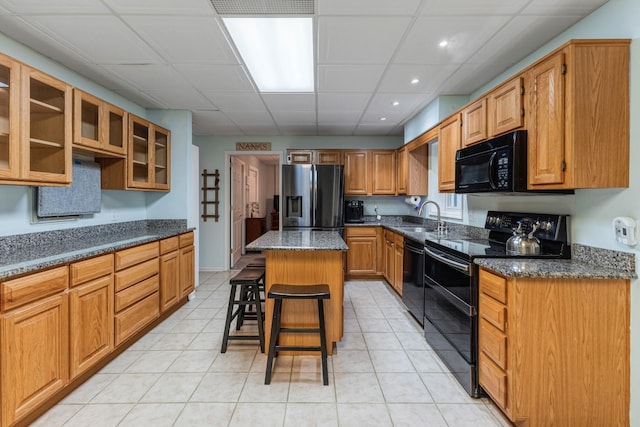 7274 Kingston Rd, Fairview, TN 37062 - kitchen featuring a sink, black appliances, glass insert cabinets, a kitchen bar, and a kitchen island