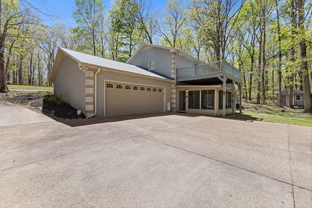 7274 Kingston Rd, Fairview, TN 37062 - view of front of house featuring a balcony, concrete driveway, an attached garage, metal roof, and stucco siding