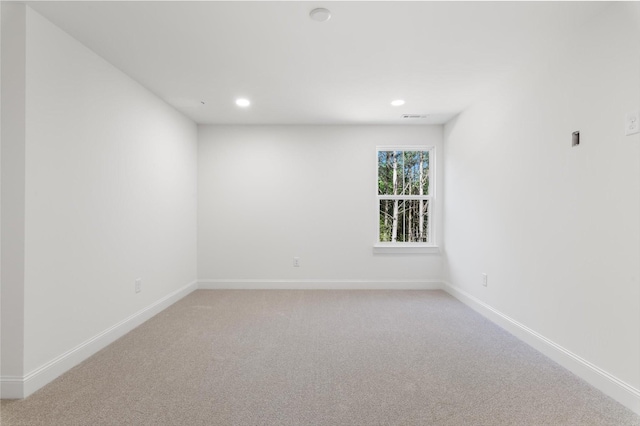 unfurnished room with visible vents, baseboards, recessed lighting, and light colored carpet