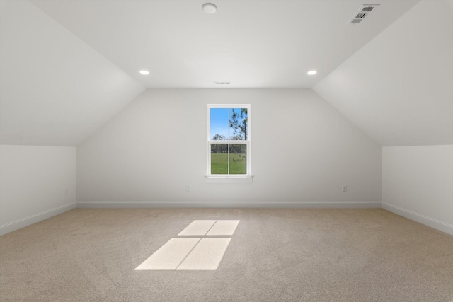 bonus room with visible vents, baseboards, light colored carpet, and lofted ceiling
