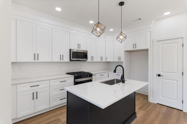 kitchen with visible vents, white cabinets, a sink, stainless steel appliances, and light wood-style flooring
