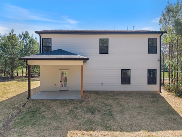 rear view of property with a patio and a lawn