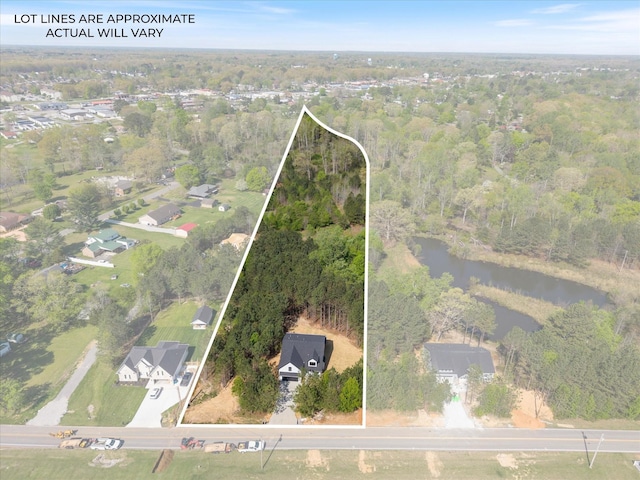 drone / aerial view featuring a water view and a forest view