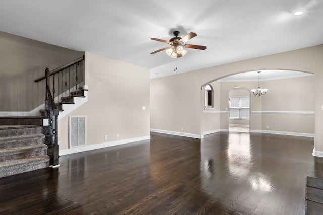 unfurnished living room with visible vents, arched walkways, stairway, wood finished floors, and ceiling fan with notable chandelier