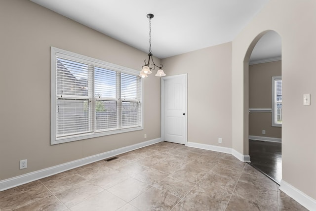 empty room with visible vents, baseboards, stone finish floor, and arched walkways