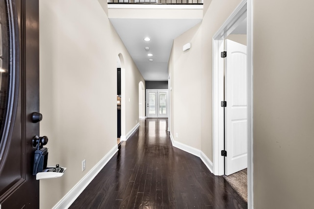 hall with recessed lighting, arched walkways, baseboards, and wood finished floors