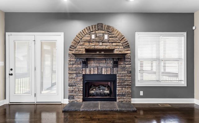 unfurnished living room with a stone fireplace, visible vents, recessed lighting, wood finished floors, and baseboards
