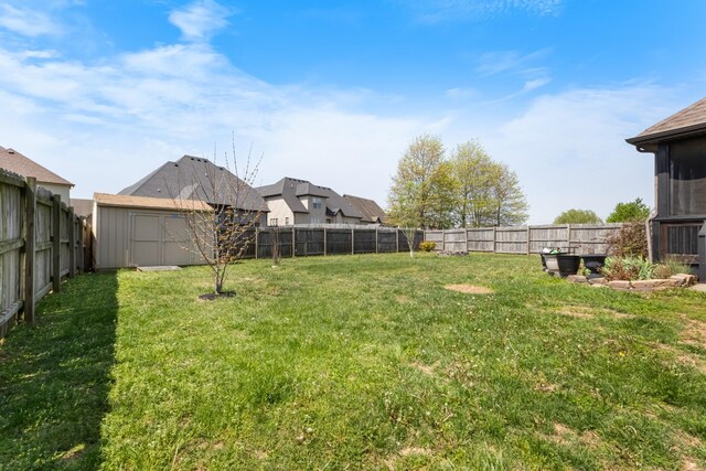 view of yard featuring a fenced backyard, an outdoor structure, and a storage unit