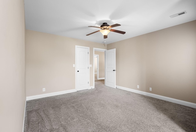 carpeted empty room with visible vents, baseboards, and a ceiling fan