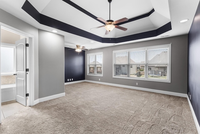 carpeted empty room with recessed lighting, baseboards, a ceiling fan, and a raised ceiling
