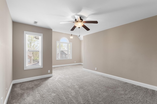 empty room with visible vents, baseboards, a ceiling fan, light carpet, and lofted ceiling