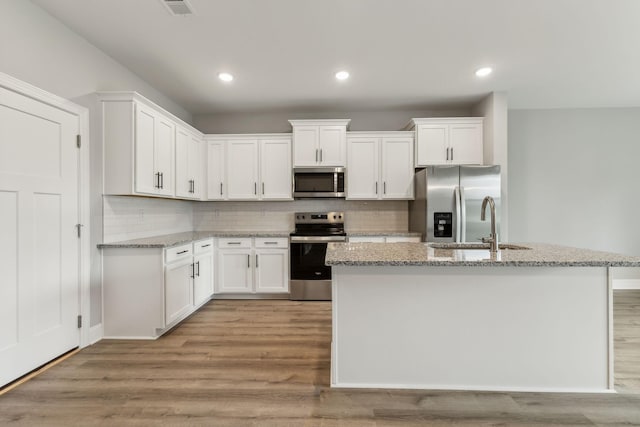 560 Twyla Dr, Lebanon, TN 37087 - kitchen with appliances with stainless steel finishes, white cabinetry, light wood finished floors, decorative backsplash, and recessed lighting