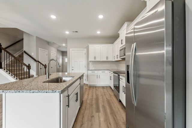 560 Twyla Dr, Lebanon, TN 37087 - kitchen with stainless steel appliances, recessed lighting, light wood-style flooring, white cabinetry, and backsplash