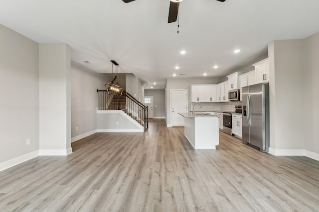560 Twyla Dr, Lebanon, TN 37087 - kitchen with appliances with stainless steel finishes, a ceiling fan, open floor plan, light wood-style floors, and a center island with sink