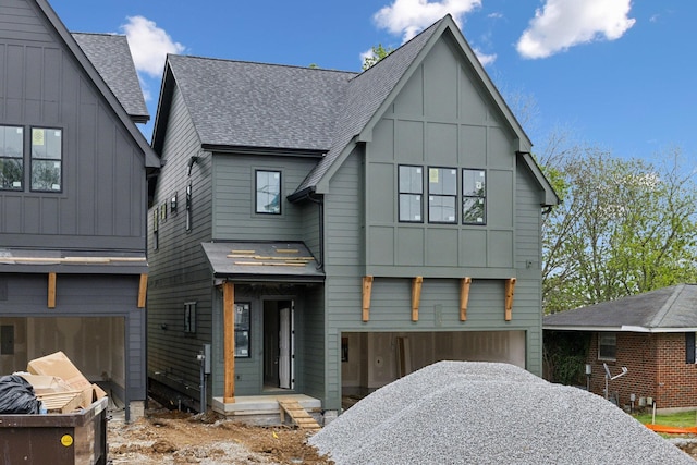 view of front of home featuring an attached garage, roof with shingles, board and batten siding, and driveway