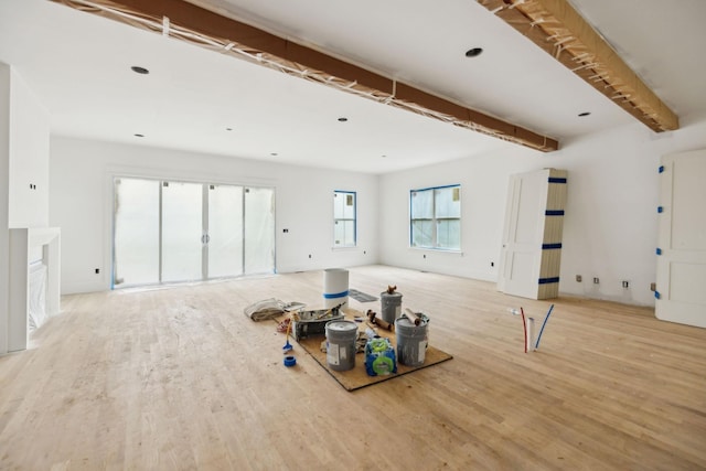 unfurnished living room featuring beamed ceiling and wood finished floors