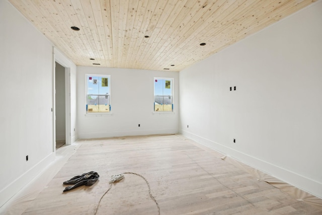 unfurnished room with baseboards, light wood-type flooring, and wooden ceiling