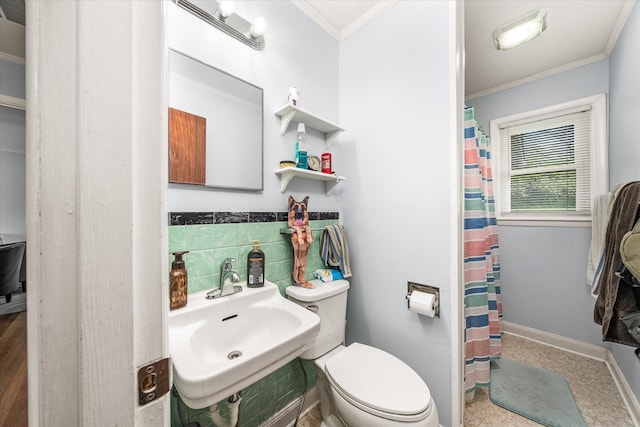 bathroom with toilet, crown molding, a shower with curtain, and a sink