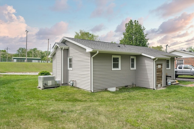 view of side of home with a lawn and central AC unit