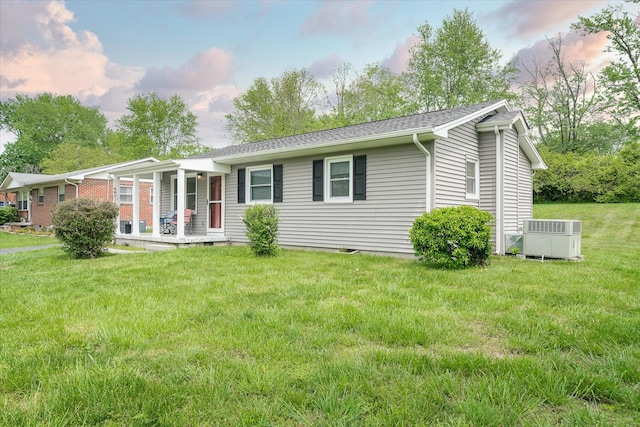 ranch-style house with a front lawn, covered porch, and cooling unit
