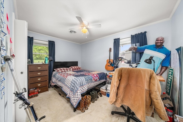 carpeted bedroom with visible vents, crown molding, and a ceiling fan