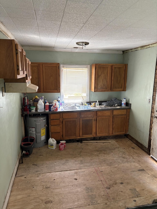 kitchen with baseboards, a sink, and brown cabinetry