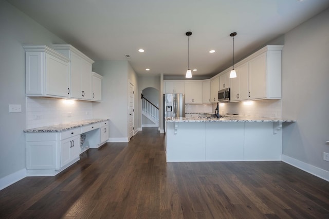 4302 Peacemill Ln, Murfreesboro, TN 37128 - kitchen featuring stainless steel appliances, arched walkways, a peninsula, tasteful backsplash, and recessed lighting
