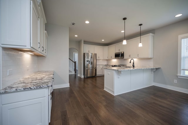 4302 Peacemill Ln, Murfreesboro, TN 37128 - kitchen with stainless steel appliances, a peninsula, tasteful backsplash, arched walkways, and white cabinets