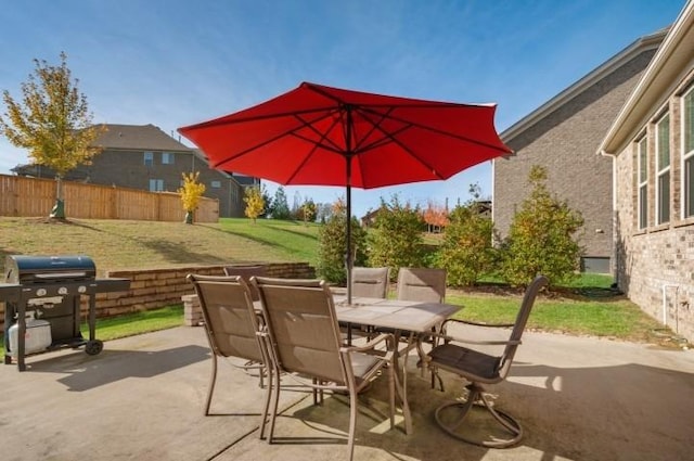 view of patio featuring a grill, fence, and outdoor dining area