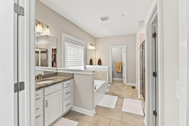 bathroom with visible vents, vanity, tile patterned floors, a stall shower, and a garden tub