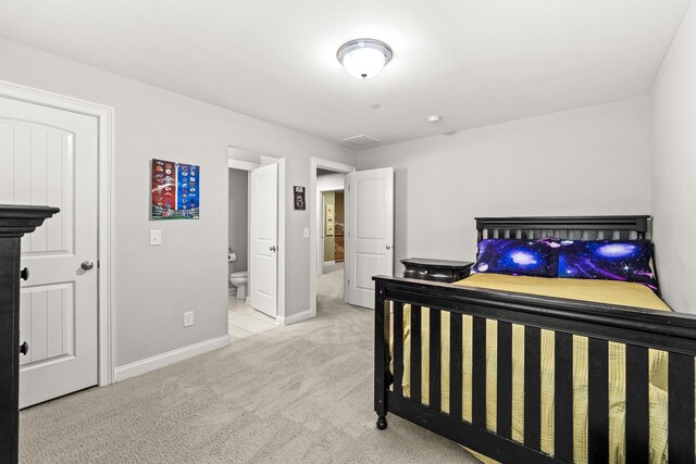 bedroom featuring ensuite bathroom, baseboards, and carpet floors