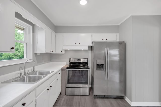 305 Thomas Ave, Hohenwald, TN 38462 - kitchen featuring stainless steel appliances, light wood-style floors, under cabinet range hood, a sink, and white cabinetry